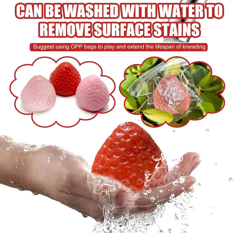 A hand is washing a red strawberry squishy fidget toy under running water.