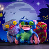 A colorful plush monster doll with big teeth and a tongue, displayed against a dark background.