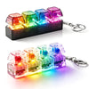 A set of illuminated keyboard key fidget toys in various colors, packaged with a metal keychain.