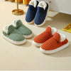 A collection of women's cozy faux fur slippers in navy blue, olive green, and burnt orange colors displayed on a light surfac