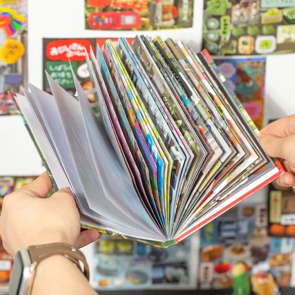 A hand holds an open stack of colorful retro K-Pop themed decorative stickers for laptops and stationery.