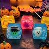 A set of four translucent squishy toys shaped like ghosts and pumpkins on a dark surface.