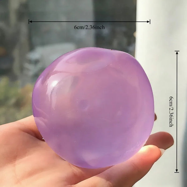 A hand holds a smooth, translucent lavender silicone fidget toy for stress relief.