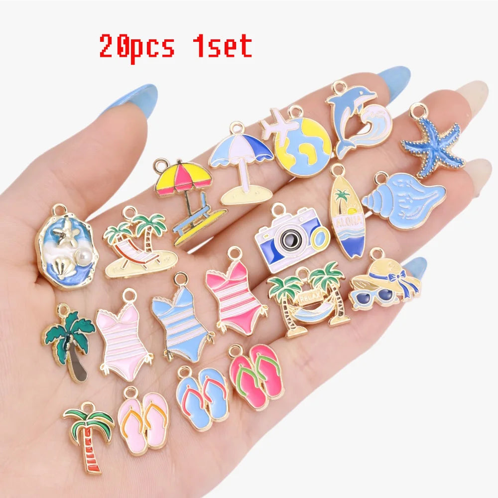 A hand displays a set of 20 enamel marine life charms for jewelry making, featuring various sea creatures and items.