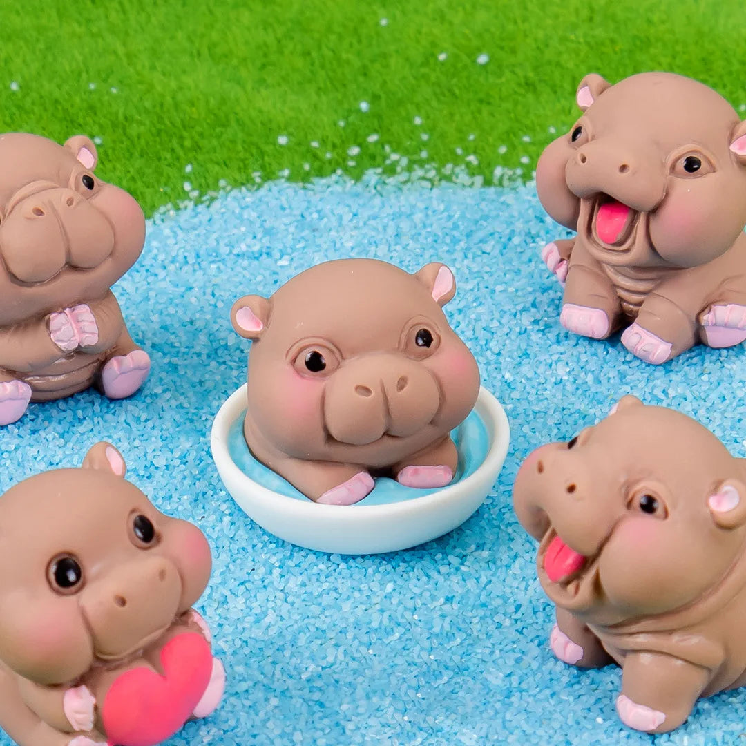A collection of cute mini hippo resin figurines in various shades of brown and pink sitting on a bright blue textured surface