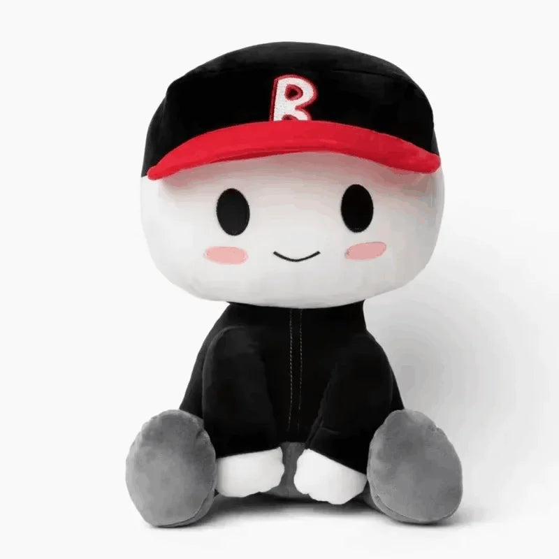 A black plush cartoon character with a red hat featuring a white 'R' emblem, sitting down.
