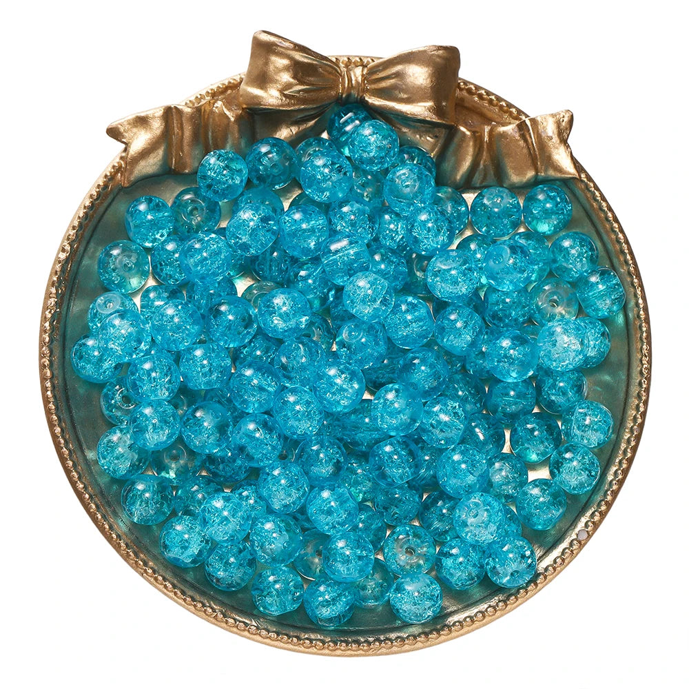 A round dish filled with bright blue glass crackle beads tied with a gold ribbon.