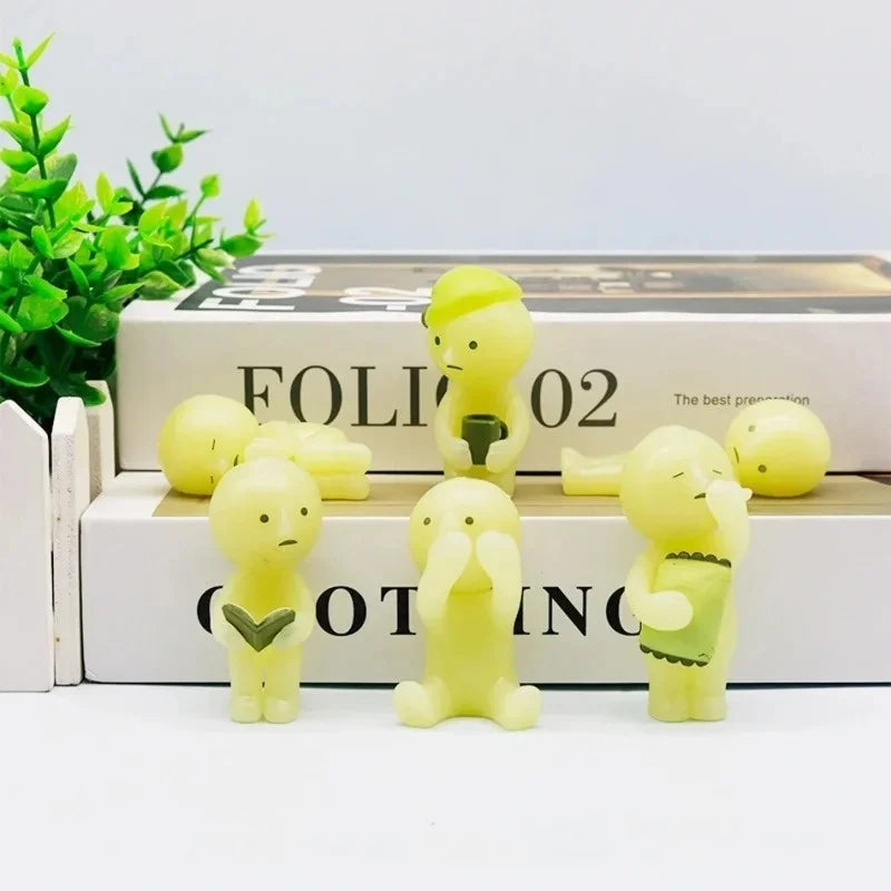 A collection of yellow glow-in-the-dark elf figures displayed on a white box.