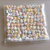 A clear plastic bag filled with a variety of pastel colored kawaii cat paw squishy stress relief fidget toys