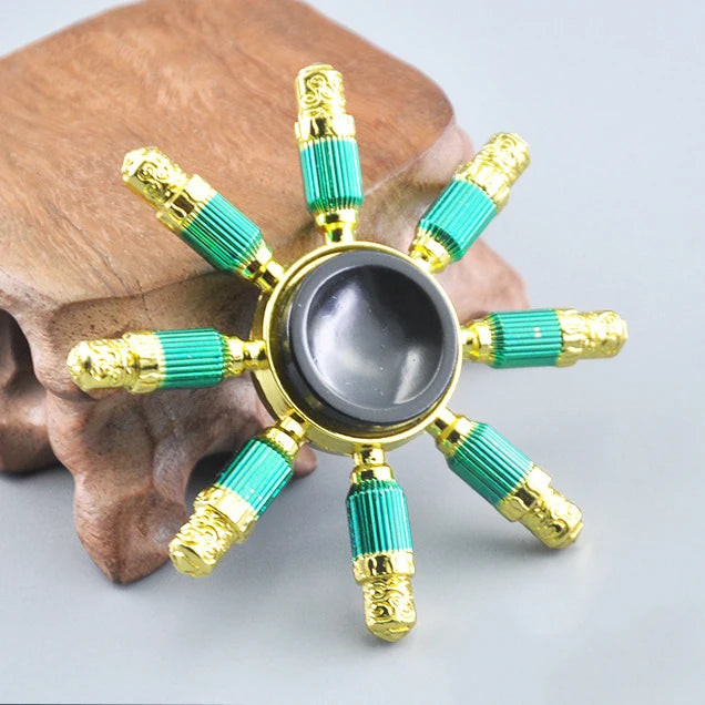 A metal fidget spinner with a rainbow finish is displayed on a brown surface.