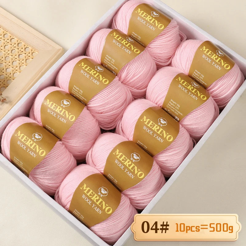 Box of Merino wool yarn balls in pink and gold labels, packaged for knitting projects.