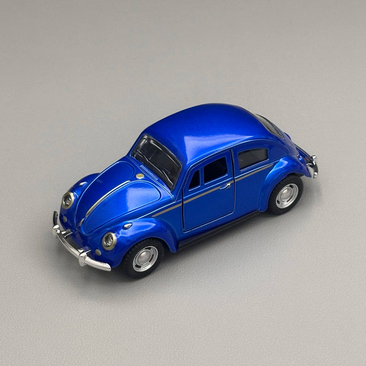 A bright blue classic retro Beetle diecast model car with black trim and chrome accents.