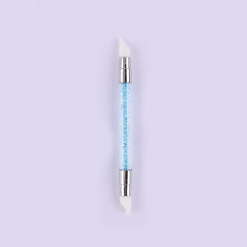 A dual-ended silicone head nail art dotting pen with a crystal handle, featuring a clear blue substance.