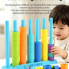 A child is playing with a colorful color sorting and matching educational toy set featuring stacking rods and rings.
