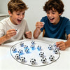 Two boys are playing with a magnetic soccer strategy board game on a white table.