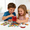 Two children play a colorful speed bead grabbing board game with a bell for two players on a white table.