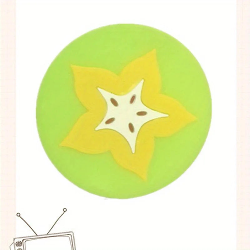 A round green coaster with a yellow flower pattern on top.