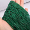A close-up of a green beaded bracelet made from faceted natural stone beads being worn on a hand.