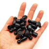 A hand holds a set of ten black wooden chess pawns for board games.