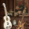A DIY guitar model kit featuring a wooden miniature guitar and a gold-accented electric guitar, displayed on a wooden surface
