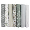A pack of seven rolls of cotton fabric squares for quilting and patchwork in various striped and patterned fabrics.