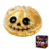 A golden pumpkin shaped squishy stress ball toy with carved facial features.