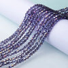 A close-up of purple and blue faceted glass crystal beads strung together for jewelry making.