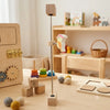 A wooden Montessori sensory activity board featuring gears, switches, and a bird-shaped component for toddlers.