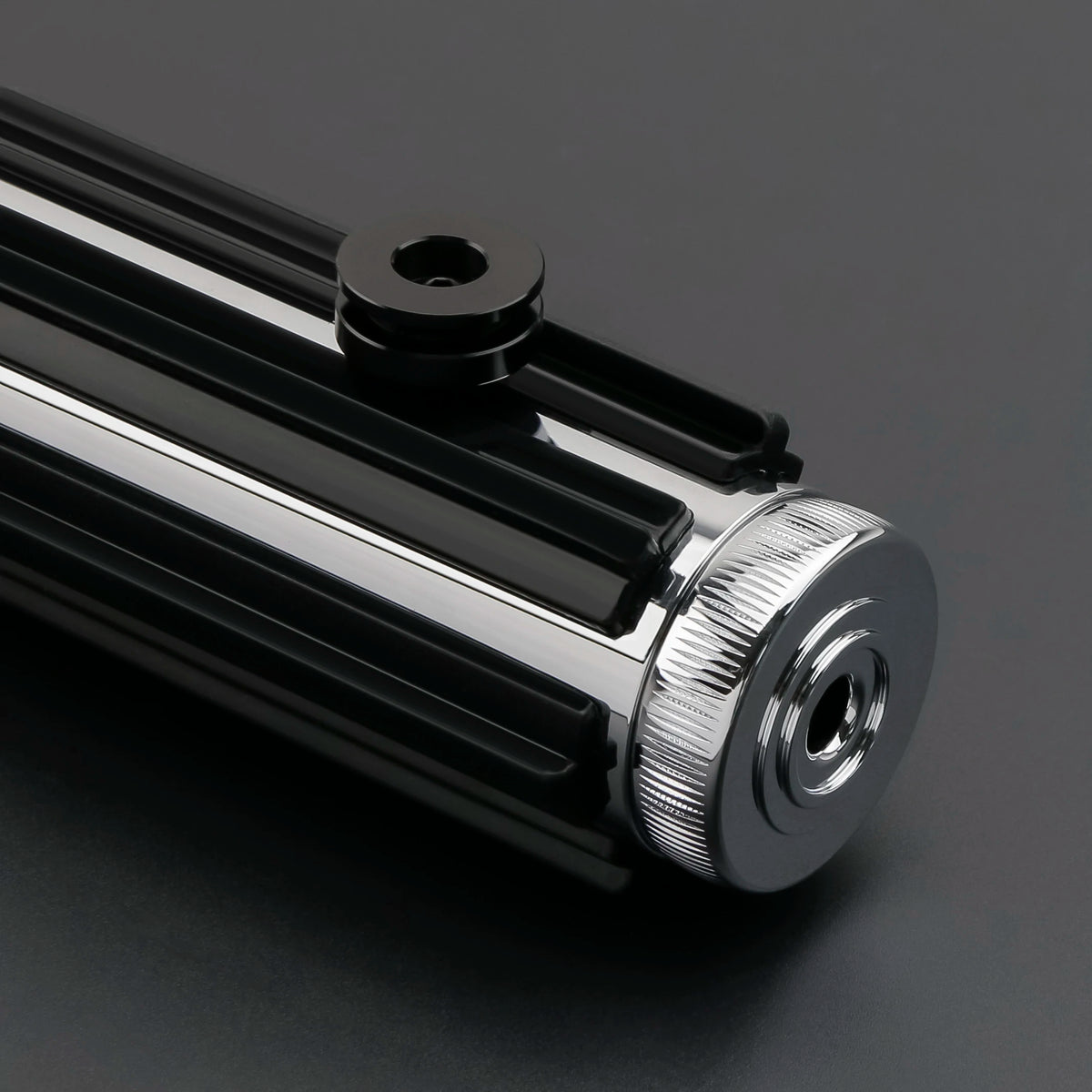A close-up view of a black Darth Vader Neopixel lightsaber with a silver hilt and soundboard component.