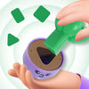 A hand is holding a purple sorting toy with a green piece, demonstrating graphical cognitive ability.