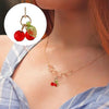 Gold chain necklace with red cherry glass charms and green leaves