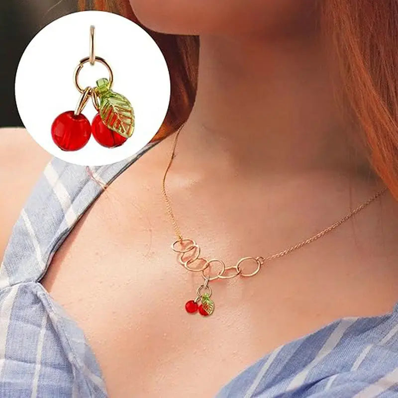 Gold chain necklace with red cherry glass charms and green leaves