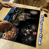 A scratch art kit featuring a night cityscape with fireworks on a wooden surface.
