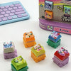 A collection of colorful fidget keychains and a purple mechanical keyboard are displayed on a white surface.
