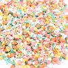 A pile of colorful polymer clay flower charms in various shades including pink, orange, yellow, and green.
