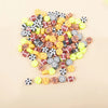 A pile of 100 polymer clay sport ball beads in various colors and patterns for jewelry making