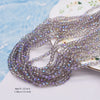 A strand of faceted purple and gray crystal rondelle beads for jewelry making laid on a white surface.