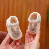 A pair of beige soft sole sandals for a baby featuring a cute embroidered bunny design.