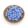 A pile of small, round, light blue silicone beads in a wooden bowl for jewelry making.