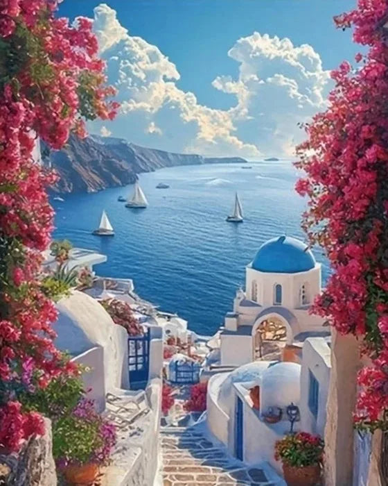 A scenic view of white architecture overlooking the sea with pink cherry blossoms in the foreground.