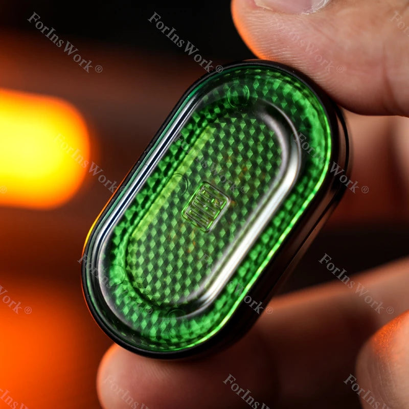 A hand holds a green metal mechanical fidget slider with a diamond pattern design.