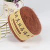 A ball of brown mohair yarn with a tan label is displayed next to a gold wire rack.