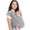 A woman is wearing an ergonomic multi-functional baby sling carrier while looking at the camera.