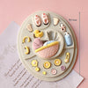 A set of baby-themed silicone cake molds including a stroller, bottle, pacifier, and various other shapes.