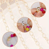 Close-up view of gold lobster clasps and open jump rings for jewelry making, shown on a delicate chain.