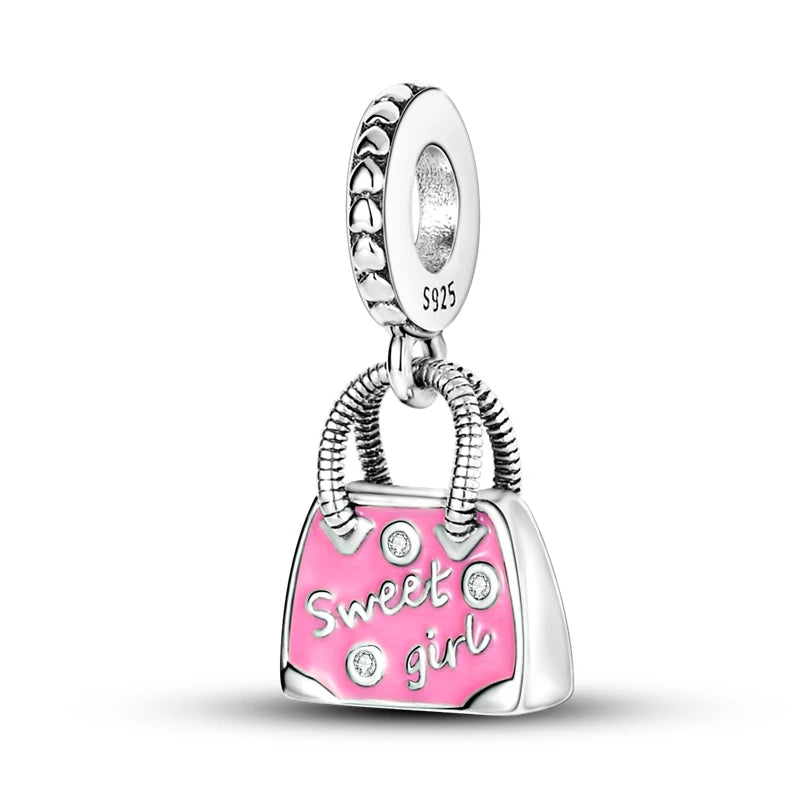 A silver heart charm bead with a pink zircon and a bail, set in a sterling silver finding.