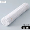 A white cylindrical roll of craft material, likely chenille stems, is shown diagonally on a light gray surface.