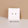 A white square jewelry display card with two small holes is shown on a light surface.