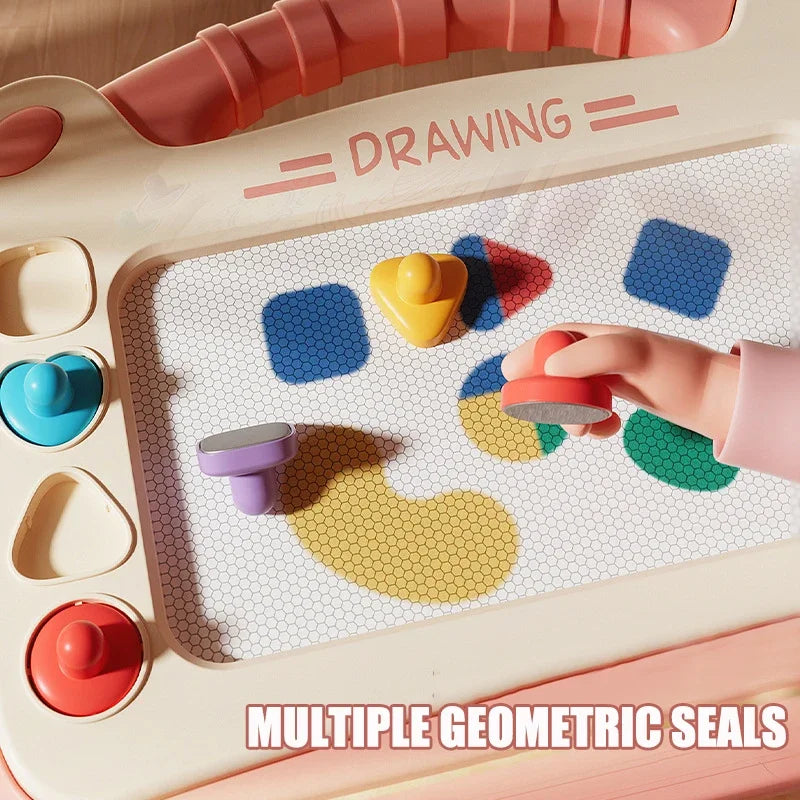 A close-up of a magnetic drawing board for kids showing various geometric seals and colorful shapes being placed by a hand.