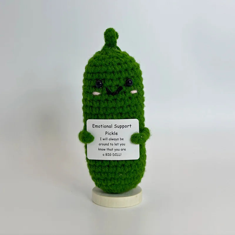 A handwoven green crochet pencil ornament shaped like a cactus with a smiling face.